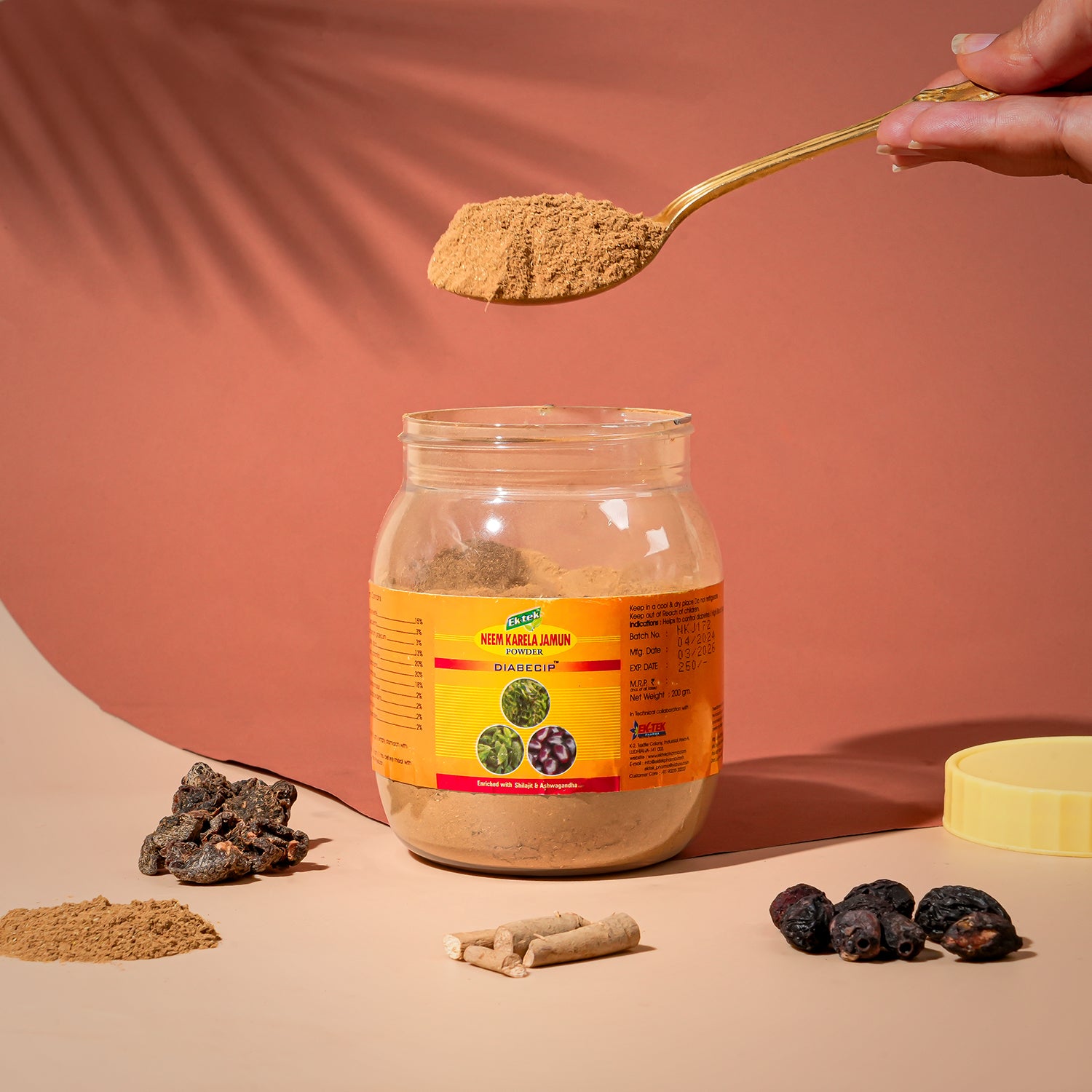 Box of Karela Jamun Powder with herbs surrounding it and a hand taking a handful of it out.