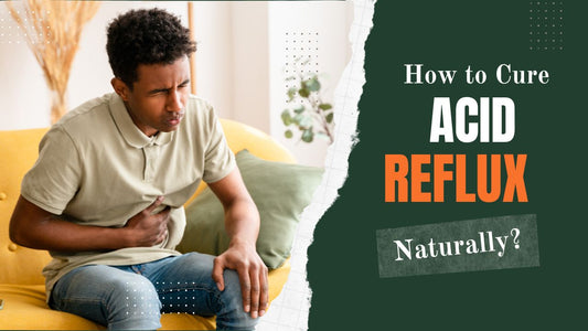 Black man sitting on sofa with hand on stomach because of acidity